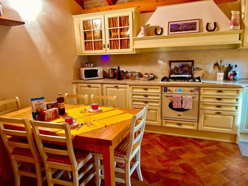 une cuisine avec une table en bois entourée de chaises. dans l'établissement Appartamento Corte Antica con splendida Jacuzzi, à Bellagio