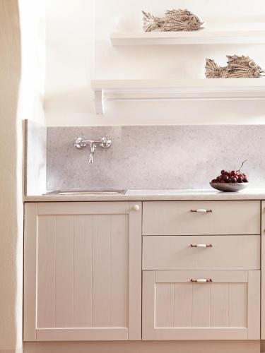 a kitchen counter with a sink and a bowl of fruit at Themonies Luxury Suites in Chora Folegandros
