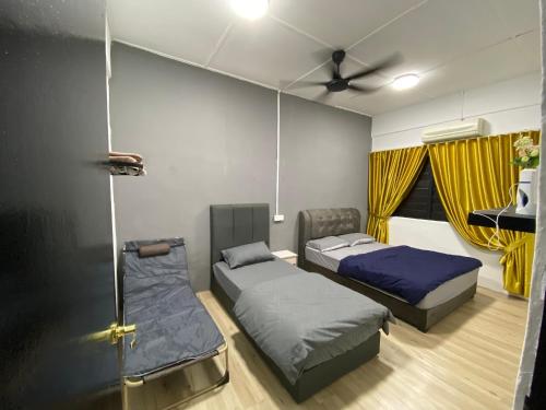 a room with two beds and a ceiling fan at Pagoh Town Homestay in Pagoh