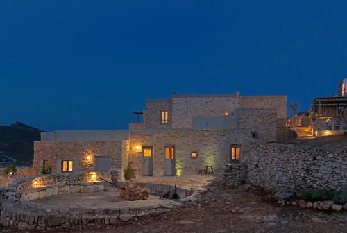 a stone house at night with lights on it at Themonies Luxury Suites in Chora Folegandros