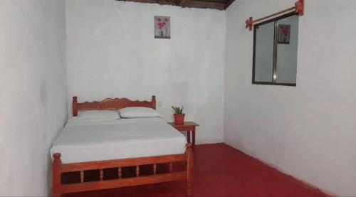Dormitorio pequeño con cama y espejo en Cabañas piedra grande ometepe, en Altagracia