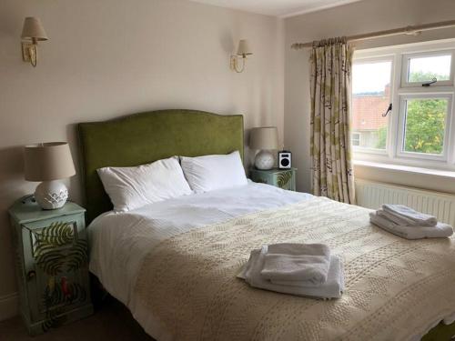 a bedroom with a bed with two towels on it at St Anthony’s, bright perkily decorated 3 bedroom house in Ampleforth