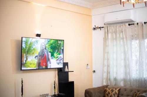 a living room with a flat screen tv on the wall at Hypo Guest Lounge in Yaoundé