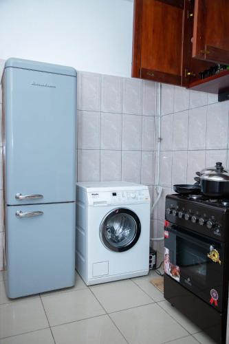 a kitchen with a washing machine and a refrigerator at Hypo Guest Lounge in Yaoundé