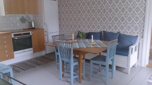 een keuken met een houten tafel met stoelen en een eetkamer bij Röda stugan in Hedemora