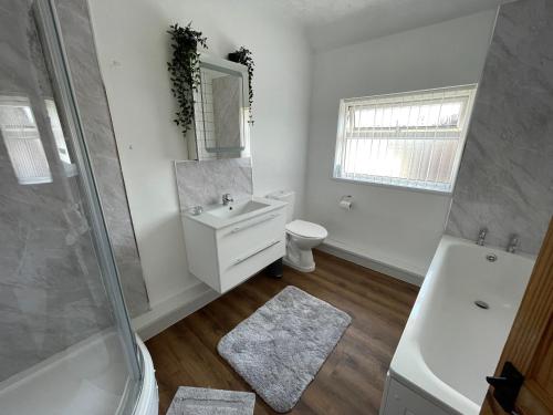 a bathroom with a sink and a toilet and a shower at Charlesworth House in Crewe