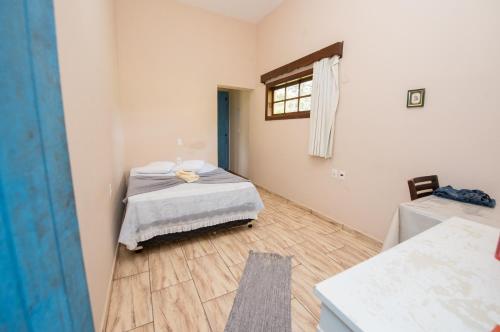 a bedroom with a bed and a window in it at Pousada No Caminho in Tambaú