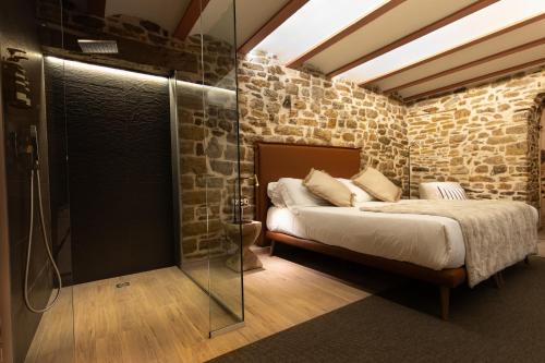 1 dormitorio con 1 cama y ducha acristalada en La Posada de Mosqueruela, en Mosqueruela