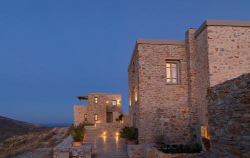 a stone house with a pathway leading up to it at night at Themonies Luxury Suites in Chora Folegandros