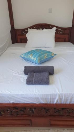 a bed with a pillow and a towel on it at Diani Hideaway Beach Villa, private pool, air conditioning and WiFi in Galu