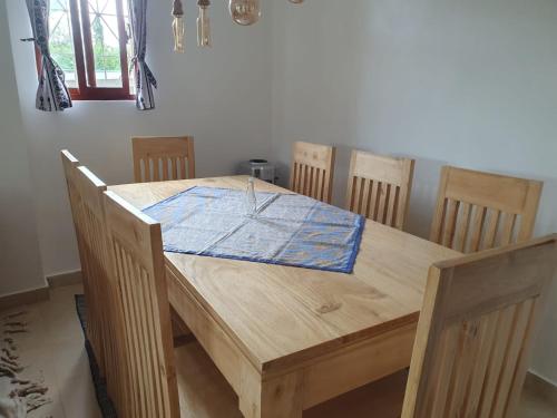 a wooden table and chairs in a room at Diani Hideaway Beach Villa, private pool, air conditioning and WiFi in Galu