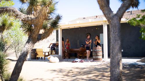 a group of people standing outside of a house at Wind Hill in Yucca Valley