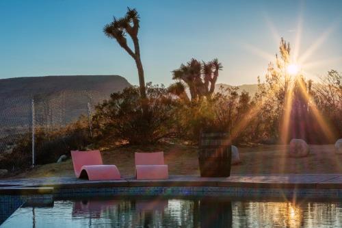 two pink chairs sitting next to a pool of water at Wind Hill in Yucca Valley