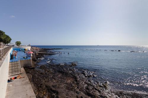 - une plage avec des personnes nageant dans l'eau dans l'établissement Flatguest Arinaga Playa 4 Caracola, à Agüimes