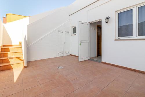 une pièce vide avec un escalier et un mur blanc dans l'établissement Flatguest Arinaga Playa 4 Caracola, à Agüimes