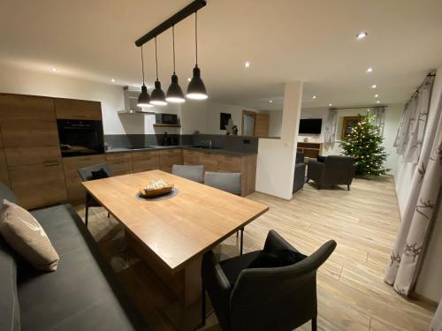 een keuken en een woonkamer met een houten tafel en stoelen bij Sandi`s Ferienhaus in Reutte