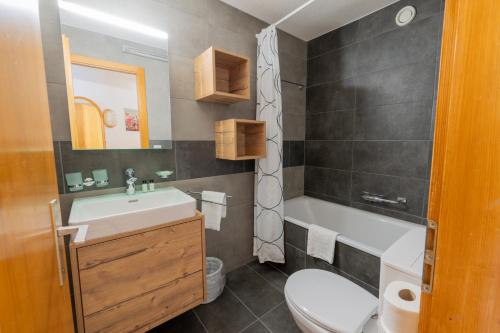 a bathroom with a white sink and a toilet at Eden Resort Anzère in Anzère
