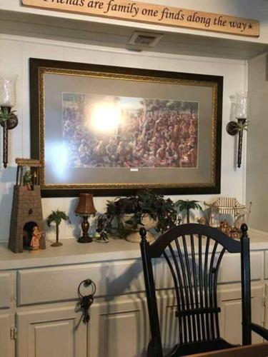 a painting on a mantle with a chair in a room at Barfoot Bay Beautiful 3/2 in Sebastian