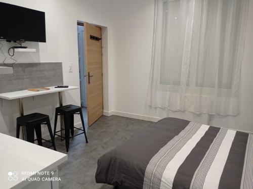 1 dormitorio con cama, escritorio y mesa en Ravissant Studio 