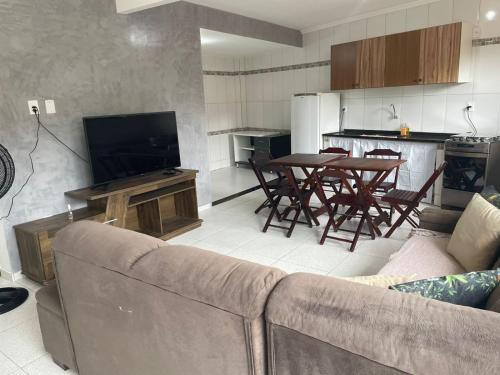 uma sala de estar com um sofá e uma mesa com cadeiras em Casa Temporada , Parque mambucaba em Angra dos Reis