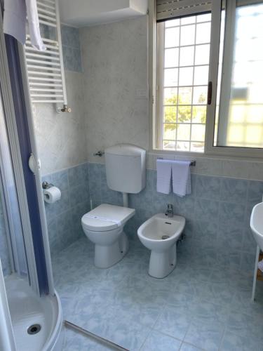 La salle de bains est pourvue de toilettes et d'un lavabo. dans l'établissement Holiday Gels appartamento vacanze Ostia, à Lido di Ostia