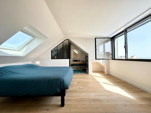 - une chambre avec un lit bleu et de grandes fenêtres dans l'établissement LUXURY ! Contemporaine neuve – Vue océan imprenable 180°, à Ploemeur