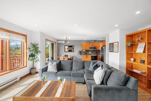 a living room with a couch and a table at Hauts-bois Ski Inout 2brs Wpool Access 197-4 in Mont-Tremblant