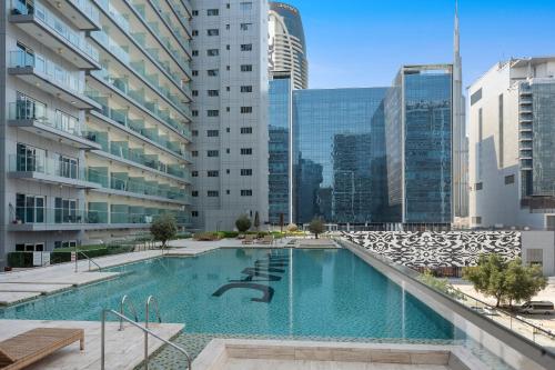 ein großes Schwimmbad in einer Stadt mit hohen Gebäuden in der Unterkunft Luxe 1BR sleeps 4, Near Burj Khalifa and Dubai Mall with Pool and free Parking in Dubai