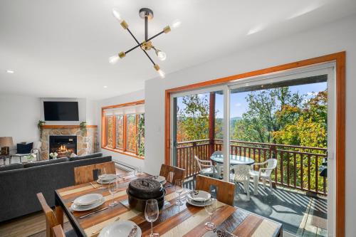 a living room with a dining table and a balcony at Hauts-bois Ski Inout 2brs Wpool Access 197-4 in Mont-Tremblant