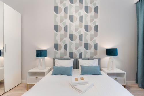 ein Schlafzimmer mit einem weißen Bett mit zwei Lampen in der Unterkunft HomeStay 3 with private parking in Toruń