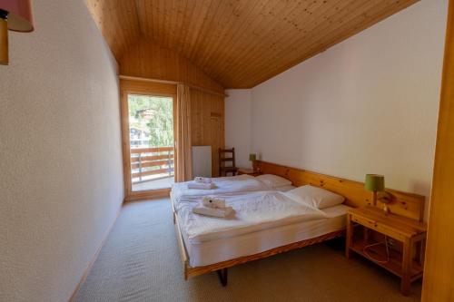 a bedroom with two beds in a room with a window at Eden Resort Anzère in Anzère