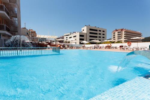 a large swimming pool with blue water in a city at Hotel Sorra Daurada Splash in Malgrat de Mar