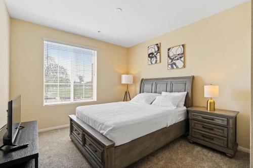 a bedroom with a bed and a desk and a television at Luxury 2BR/2BA! 5 MIN to Disney! in Anaheim