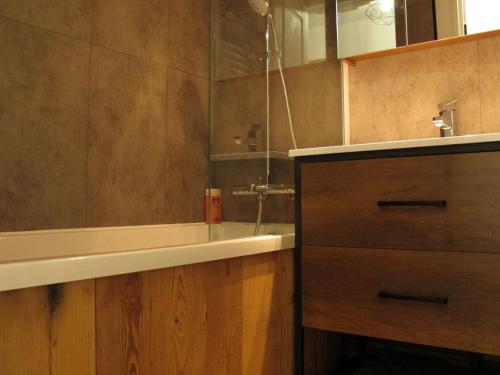 une salle de bain avec un lavabo, une baignoire et un comptoir dans l'établissement Appartement Montagne Contemporain, Rénové avec Accès Direct aux Pistes - FR-1-634-46, à Avoriaz