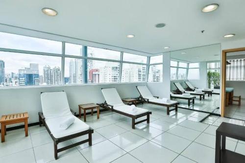 a waiting room with chairs and windows in a building at Suite executiva Park in Radisson Berrini Luxo Queen 17 in Sao Paulo