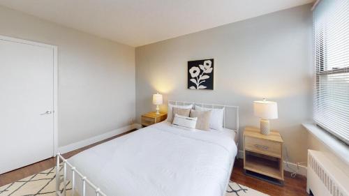 biała sypialnia z białym łóżkiem i 2 lampami w obiekcie Comfy 2br, Pool, Gym, Parking I Ave w Filadelfii
