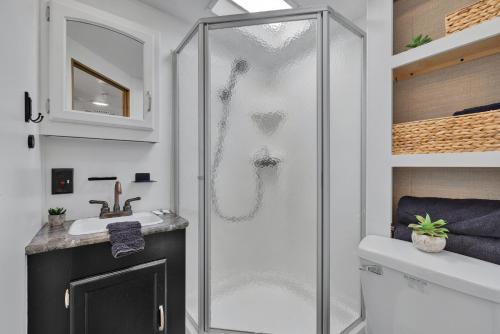 a bathroom with a shower and a sink at Lucinda Luxury RV with Hot Tub in Fredericksburg