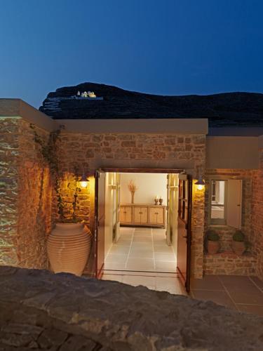 a building with an open door with a vase in the doorway at Themonies Luxury Suites in Chora Folegandros