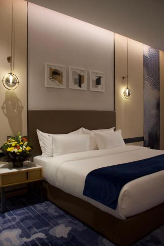 a bedroom with a large bed with white pillows at Best Western Plus Danat Almansak Hotel in Abha
