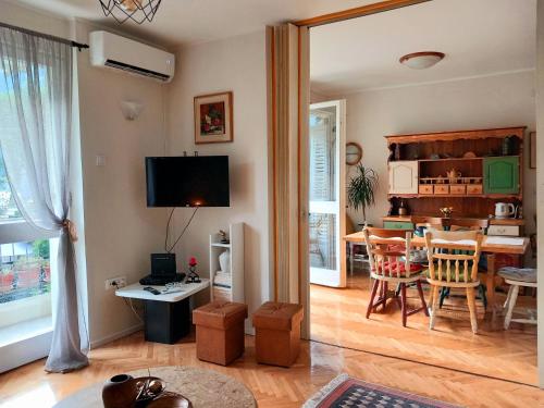 ein Wohnzimmer mit einem TV und einem Esszimmer in der Unterkunft Apartment Navigator's lodging in Kotor