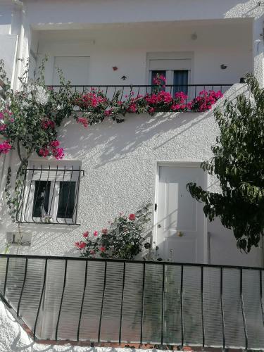 a white building with pink flowers on a balcony at Cantinho da Familia in Avis