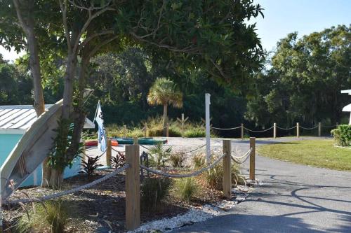 a park with a rope fence and a slide at Pinecraft Blue Heron Tiny Home in Sarasota