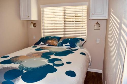 a bedroom with a bed with a blue and white comforter at Pinecraft Blue Heron Tiny Home in Sarasota