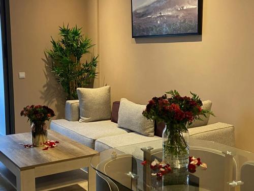 a living room with a couch and a table with flowers at Atlas-Résidence by Rent-Inn in Rabat