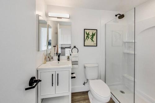 uma casa de banho branca com um WC e um chuveiro em Brand New Stylish Studio Suite Near Downtown em Oakland