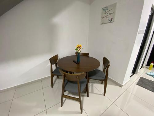 a wooden table with chairs and a vase with flowers on it at Pagoh Town Homestay in Pagoh