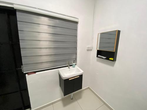a white bathroom with a sink and a window at Pagoh Town Homestay in Pagoh
