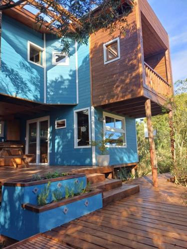 a blue house with a wooden deck at Nairandey in La Pedrera