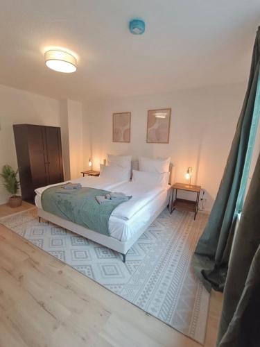 a bedroom with a large white bed and two lamps at Bright and central with 2 beds incl workspace in Bochum