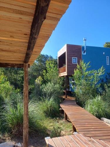 a wooden deck with a tree house in the background at Nairandey in La Pedrera